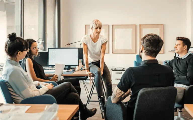 five coworkers have a meeting in an open office plan