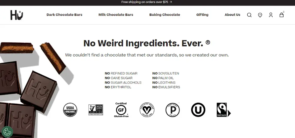 Image shows a screenshot from the Hu Kitchen homepage, featuring product shots of the brand’s chocolate against a clean white background. The title of the page reads, “No weird ingredients. Ever,” followed by a list of ingredients their products never contain.